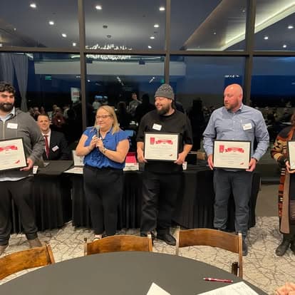Members holding award certificates at a chapter celebration