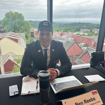 A member smiling at the head table before the meeting starts