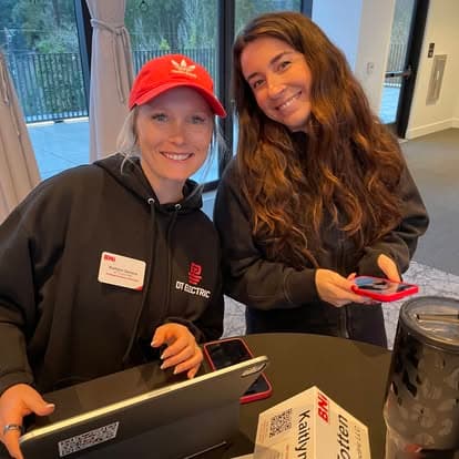 Two smiling members at the registration table
