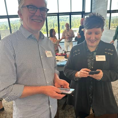 Two members swapping contact details at a meeting