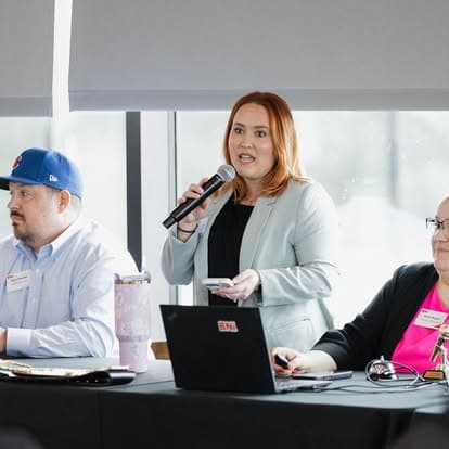 A chapter leader speaking into a microphone at the head table